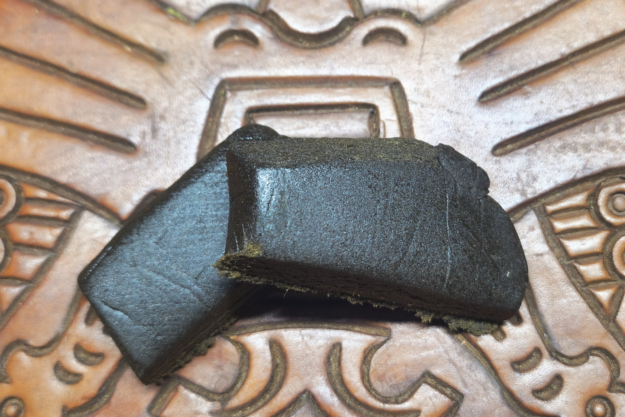 Barbol. Black polen on a textured metal surface